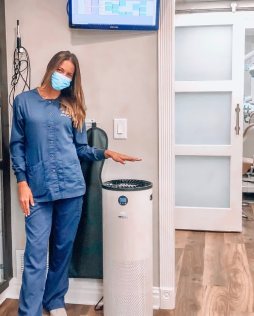 employee standing by air filtration system