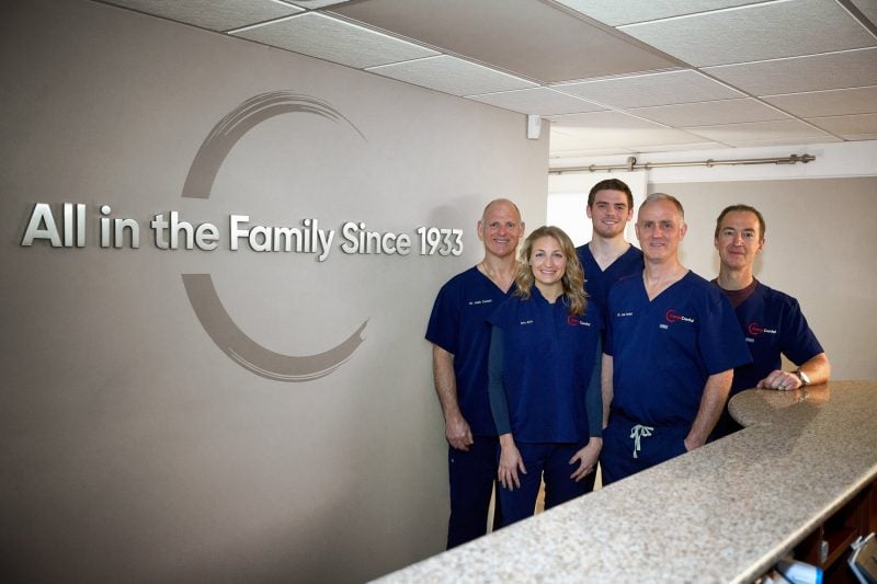 Team posing in front of the front logo